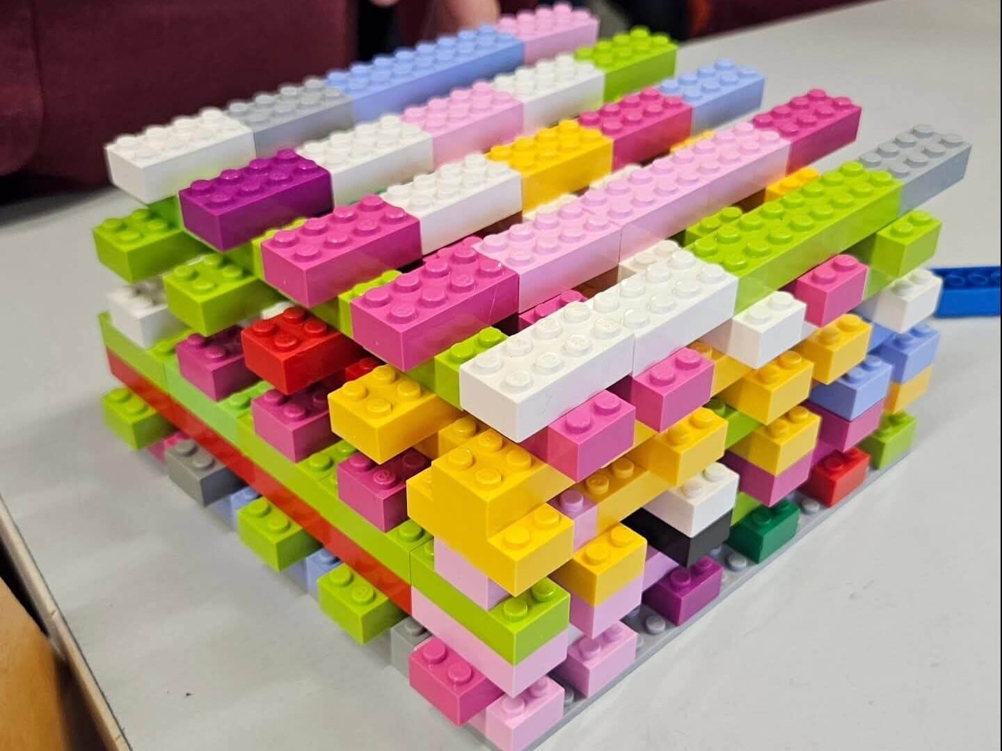 Services Layered LEGO brick structure built from overlapping rows of multicolour blocks on a table.